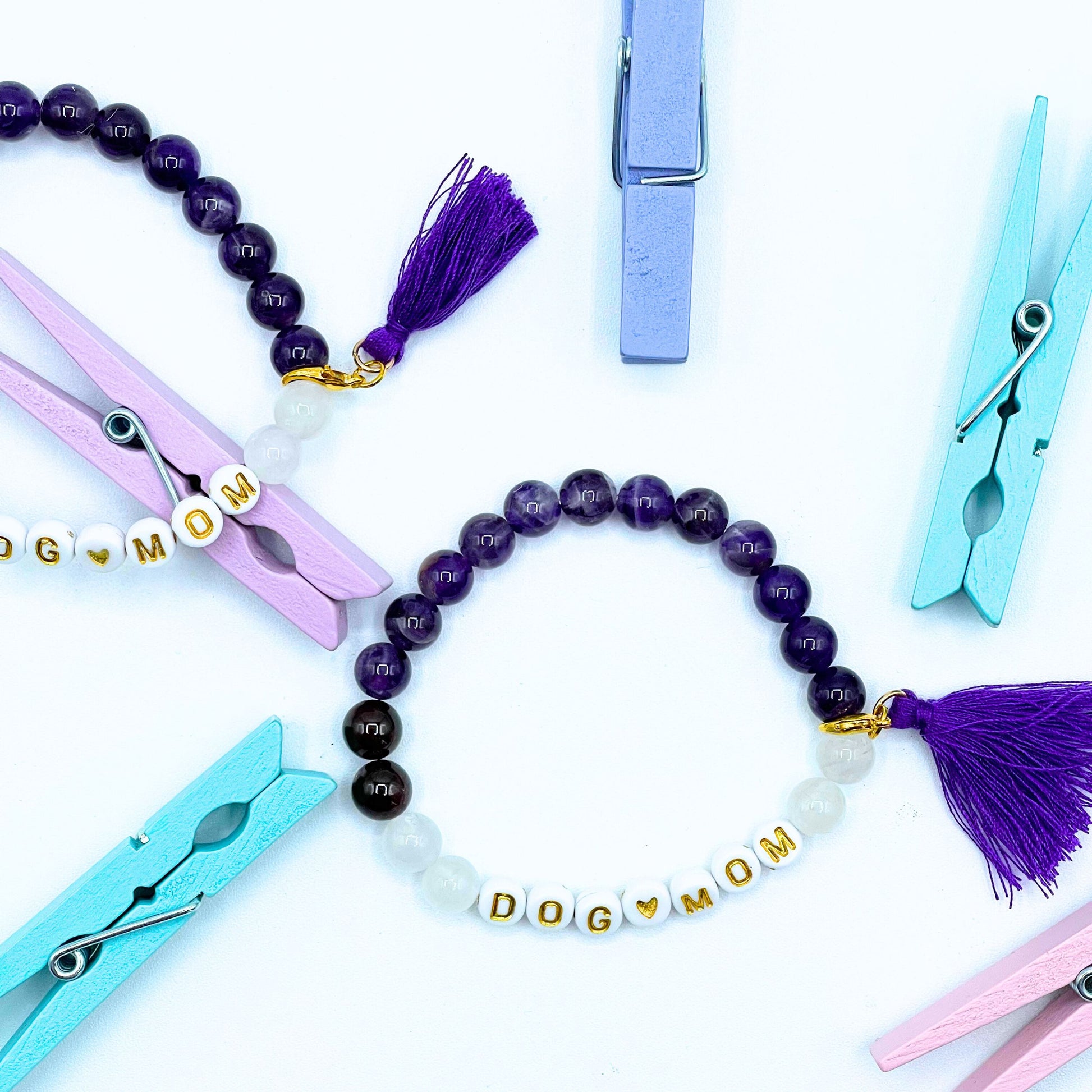 Our Amethyst 8mm beaded bracelet says "Dog Mom” with detachable tassel (gold tone lobster claw), please let me know if you would like to change any of the wording. Each piece is made to order by me (Jessica) with love and the purest intentions.