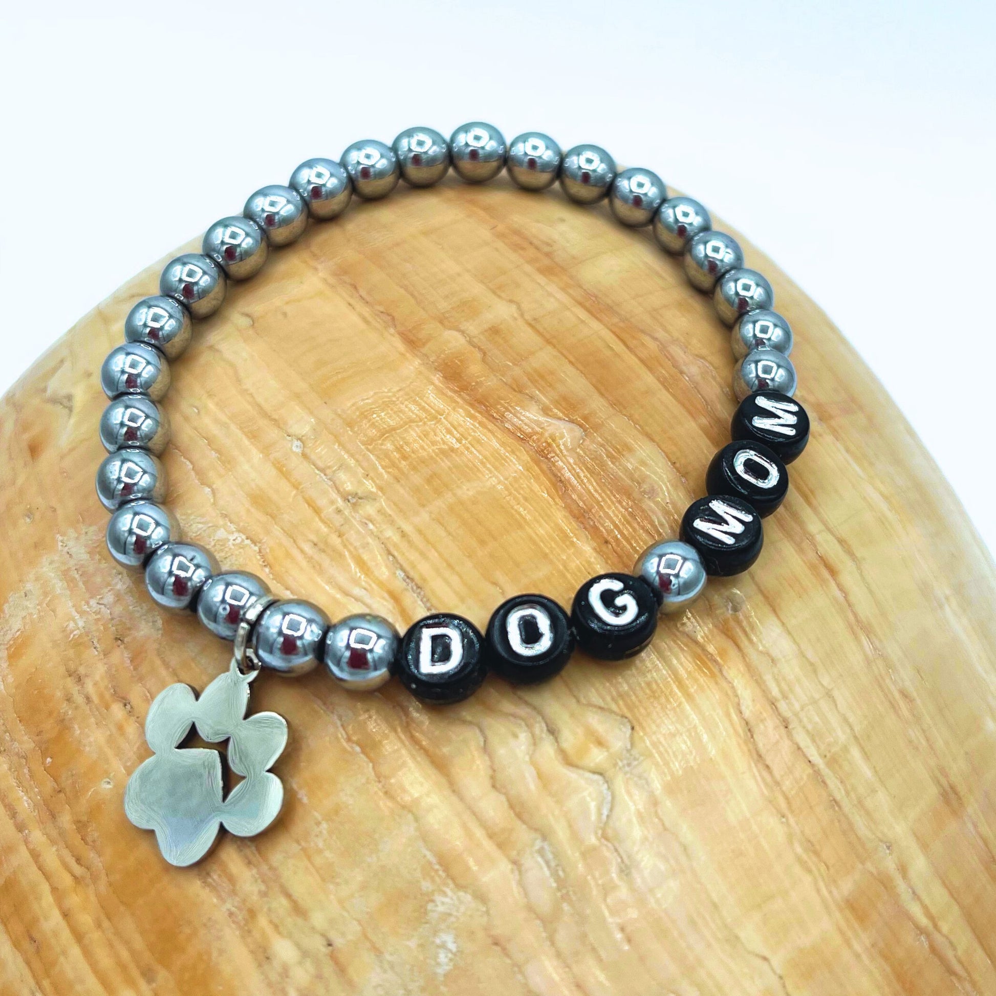 Our Silver Plated Hematite 6mm beaded bracelet says "Dog Mom” with dangly paw charm. Each piece is made to order by me (Jessica) with love and the purest intentions.